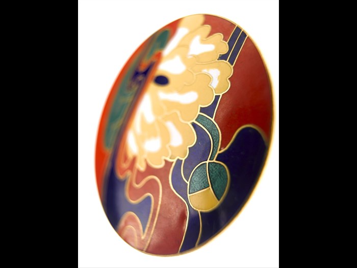 Large circular belt buckle of silver gilt featuring a Japanese style lotus flower design in coloured enamel inlay: British, designed for Jean Muir Ltd by Marks of Distinction, c. 1972.