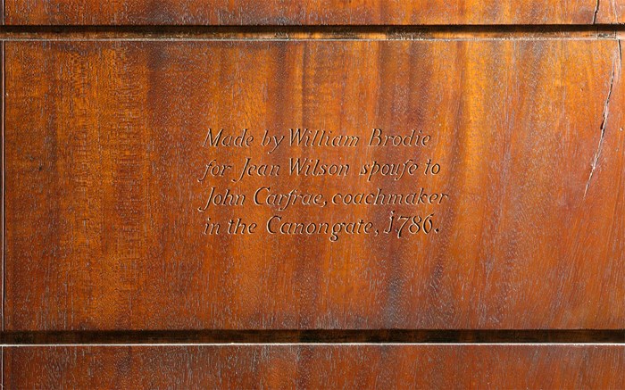 Inscription on a wooden cabinet reading, 'Made by William Brodie for Jean Wilson spouse to John Crafrae, coachmaker in the Canongate, 1786'.