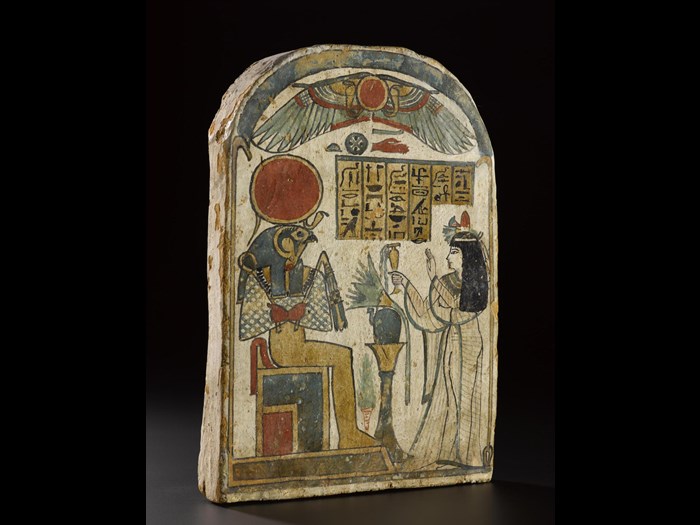 Stela of wood covered with gesso and painted, showing the Lady of the House Ta-kai worshipping Ra-Horakhty as a falcon-headed god seated on a throne: Ancient Egyptian, from Thebes, 22nd Dynasty, Third Intermediate Period, c.945-715BC.
