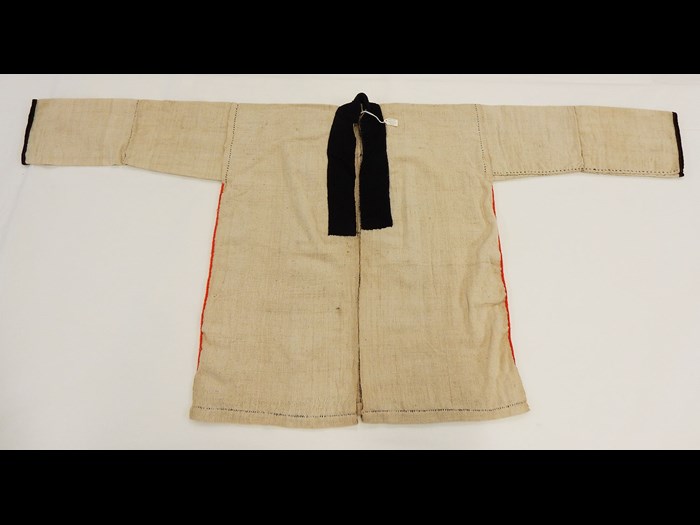 Woman's white cotton jacket with applique cotton borders and rows of fishtail overcasting in wool, worn under a black jacket: Burmese, North Thailand, Chiangrai, Lawle or Amphur Maechan, c. 1984.