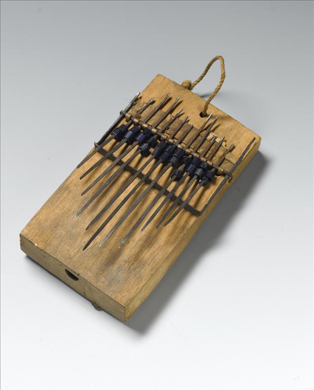 Thumb piano or likimbe, a hollowed wooden box with vibrating iron tongues, decorated with blue glass beads: Africa, Central Africa, Democratic Republic of the Congo, Lokombe, early 20th century.