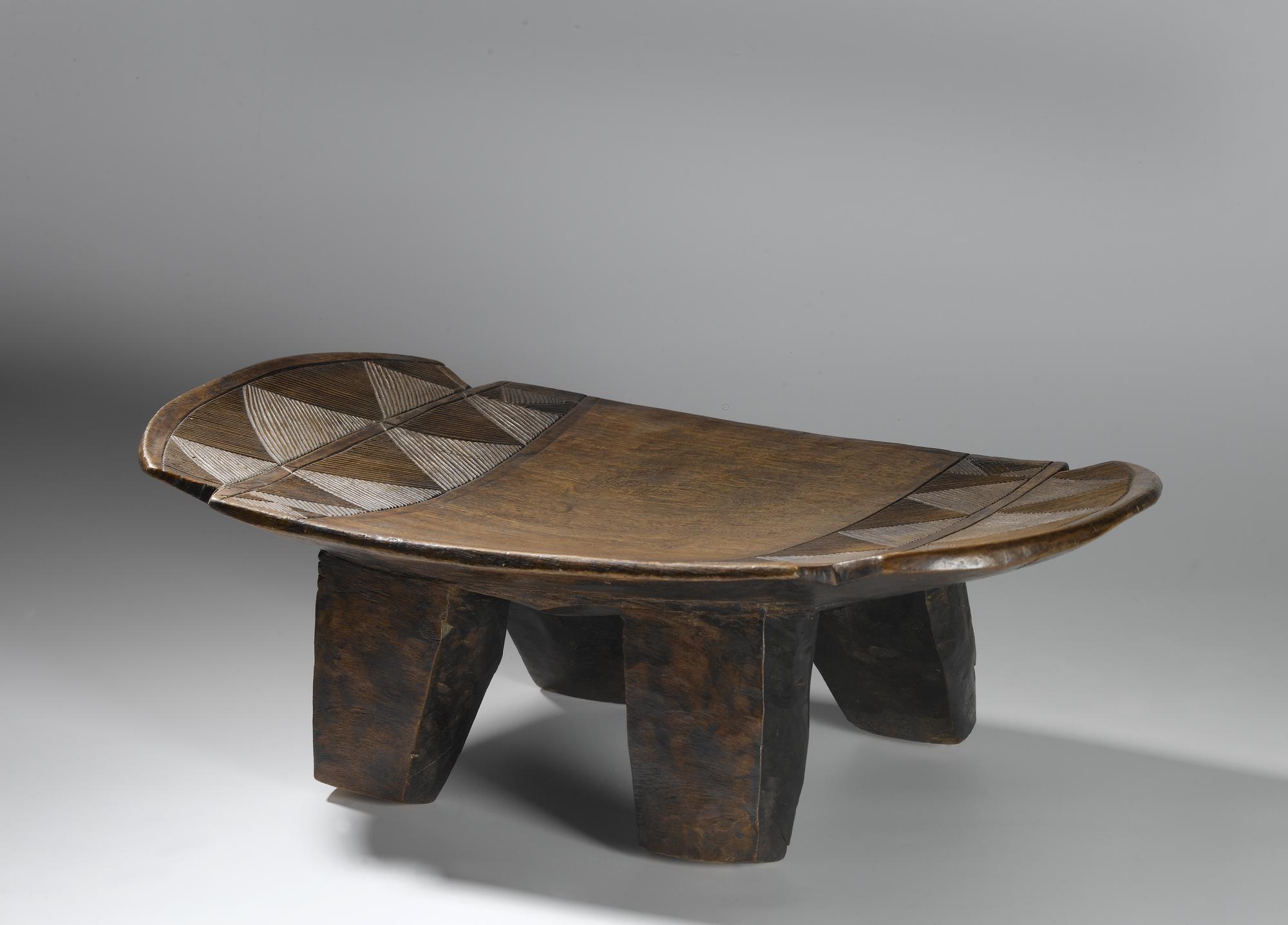 Slightly curved oblong wooden stool on four legs, with carved linear ornament: Africa, Southern Africa, Zambia, Tanganyika Plateau, Awemba, late 19th century.