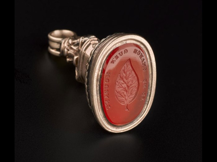 Gold and gemstone fob seal engraved with a leaf and the motto 'Je Ne Change Que'n Mourant', meaning 'I do not change except in death' – an expression of steadfast loyalty. 