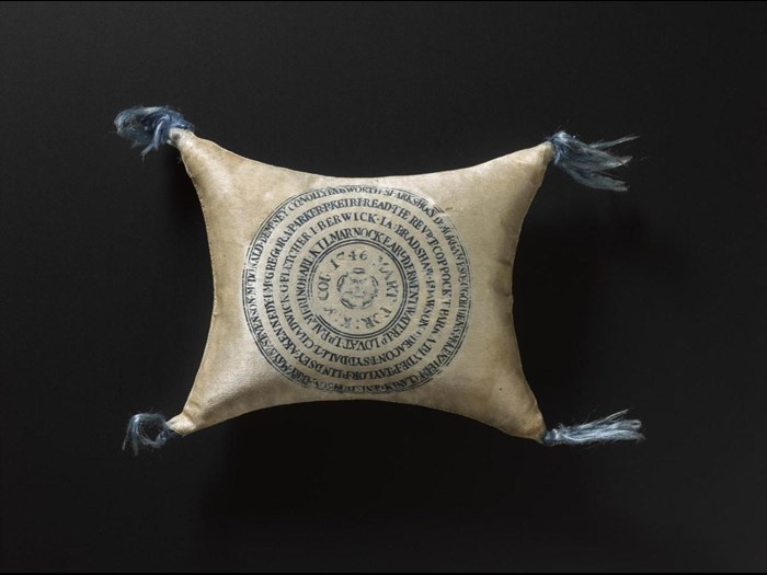 This pin cushion has 67 names are printed on it along with the words "MART: FOR:K:&COU:1746", meaning martyred for king and country 1746.