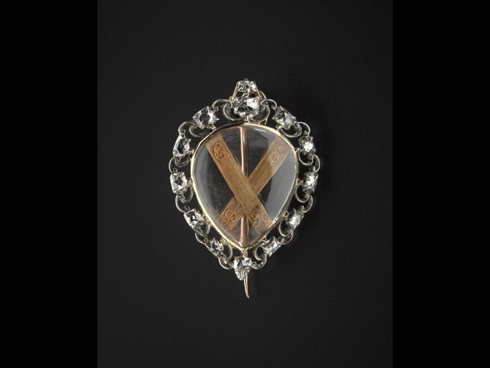 Heart-shaped brooch said to contain the hair of Prince Charles Edward Stuart and given to him by Lady Mary Clark. The hair forms the shape of a saltire with wire lettering 'C.E.P.R'.