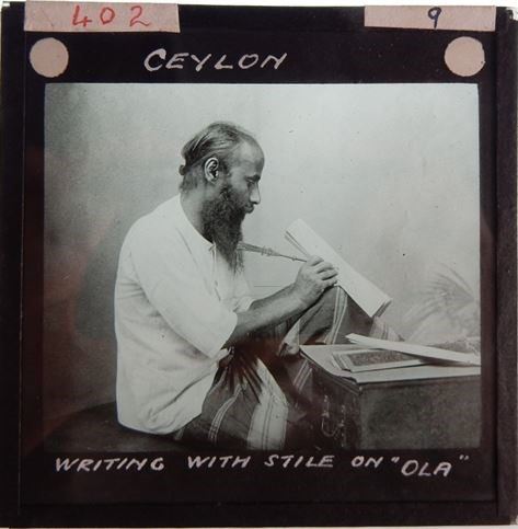 Handwritten caption: 'Ceylon / Writing with style on "Ola"''. Photographer unknown. From Im Thurn’s Lantern Slide collection, National Museums Scotland lantern slide catalogue number 402.9.