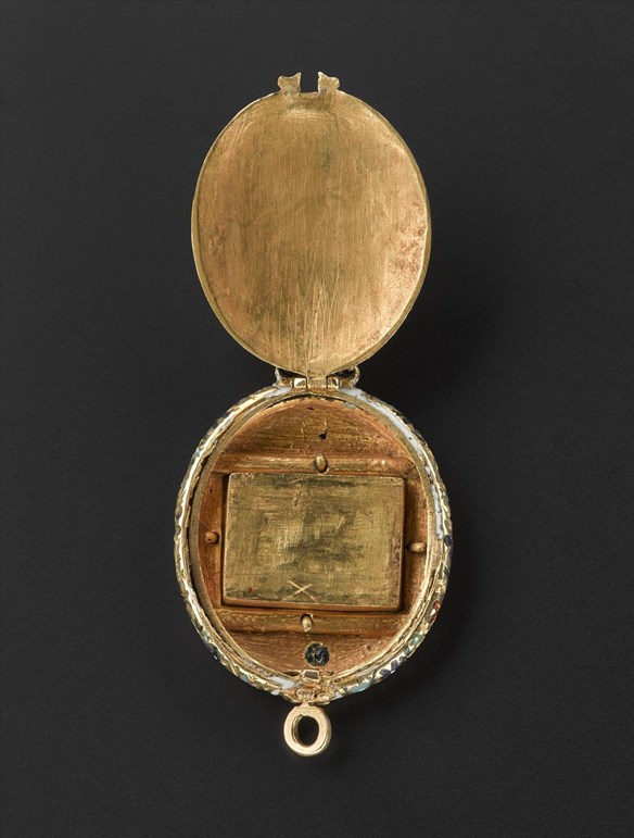 Inside of the Fettercairn Jewel. A scratched wooden panel backs the red gemstone, marked by a small 'x'.