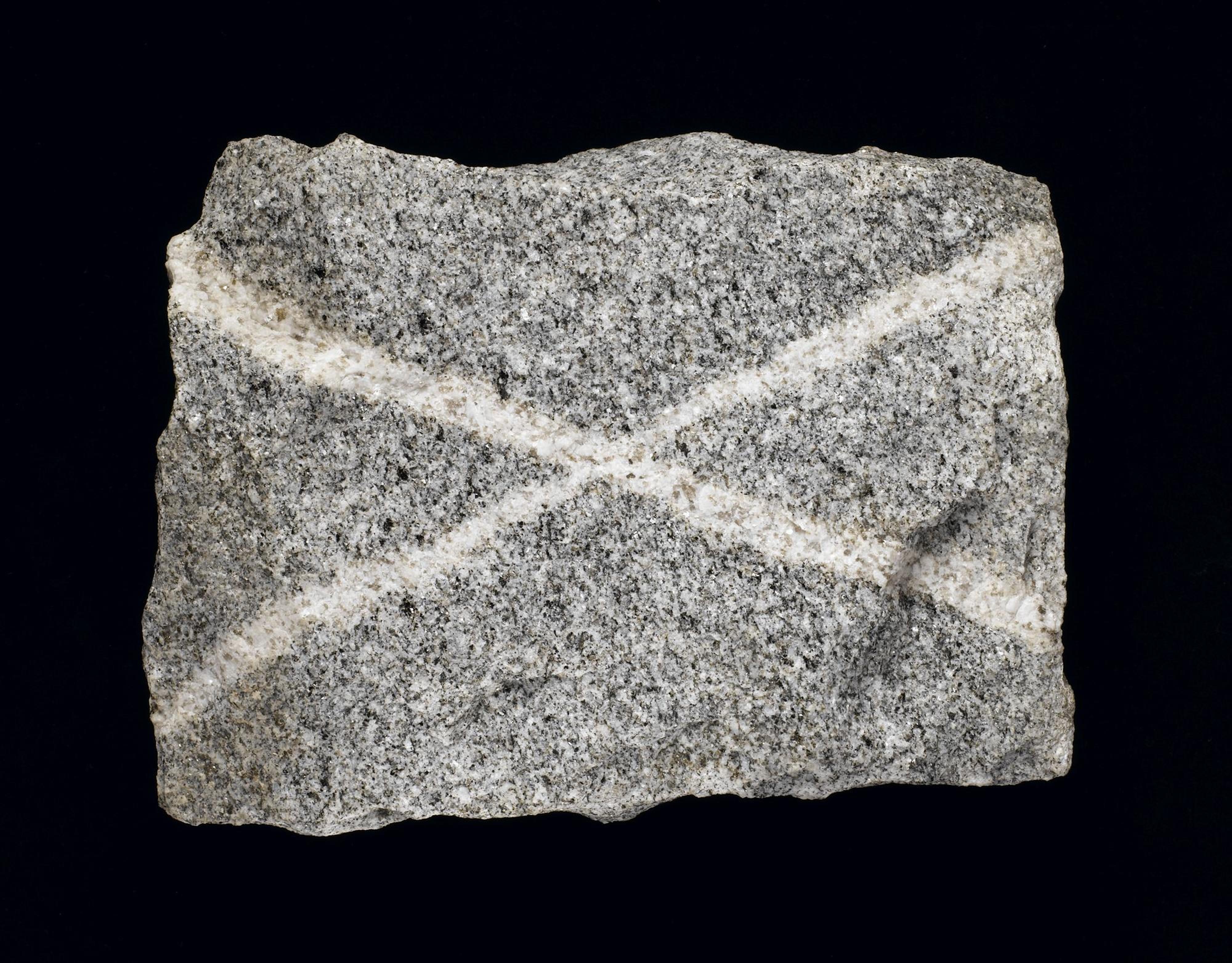 Grey granite with quartz veins, forming a saltire, from Persley Quarry, Aberdeen, Scotland. On display in the Scotland: A Changing Nation gallery at the National Museum of Scotland.