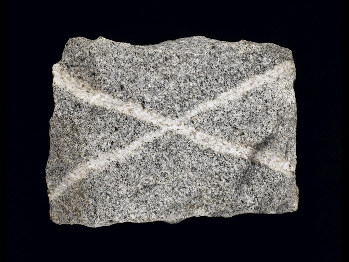 Grey granite with quartz veins, forming a saltire, from Persley Quarry, Aberdeen, Scotland. On display in the Scotland: A Changing Nation gallery at the National Museum of Scotland.