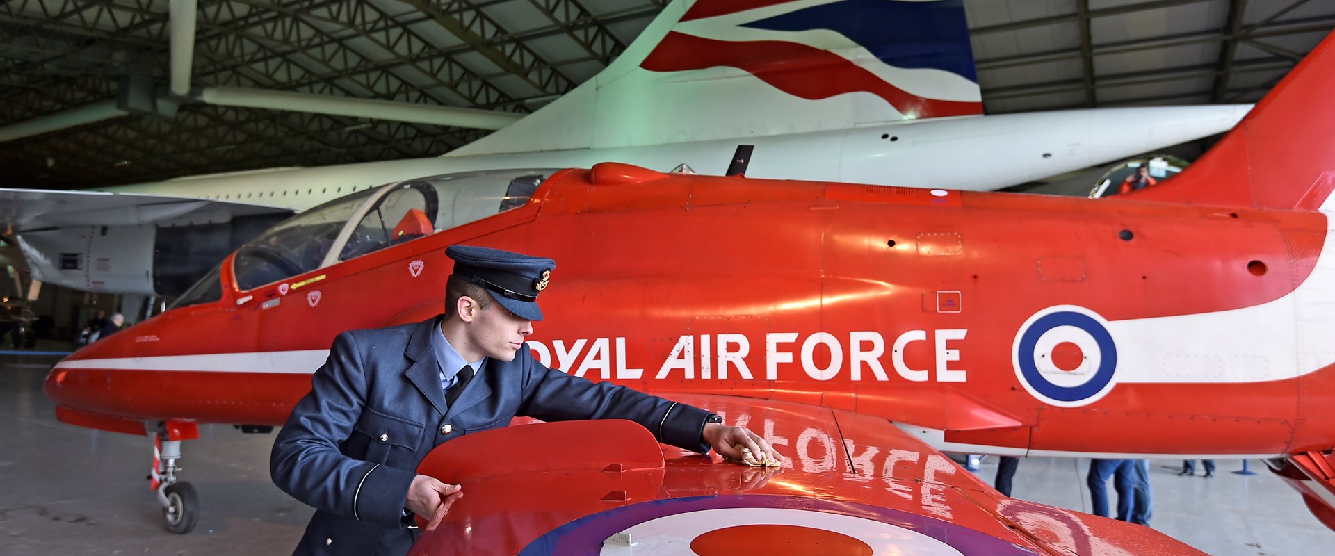 Pilot polishing the wing of the Red Arrows Hawk aircraft