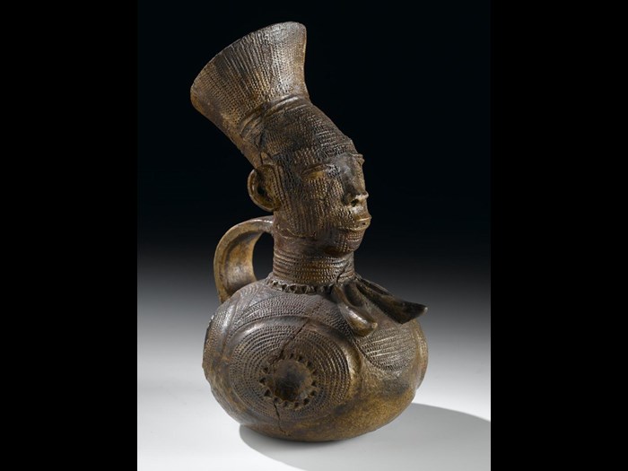 Early 20th century hand-modelled clay jug  from the Democratic Republic of the Congo, in the form of a high status Mangbetu woman with elaborate hairstyle and body decoration.