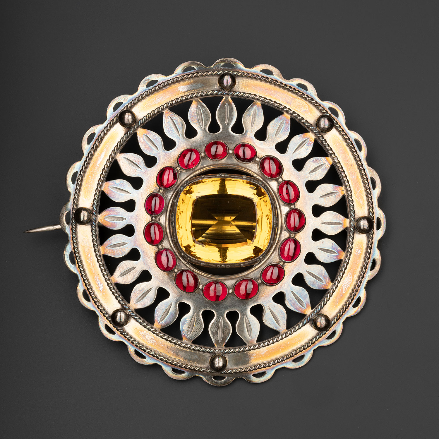 Silver plaid brooch set with a cairngorm in the centre and a ring of sixteen carbuncles round it, worn by the chiefs of Clanranald, mid-19th century.