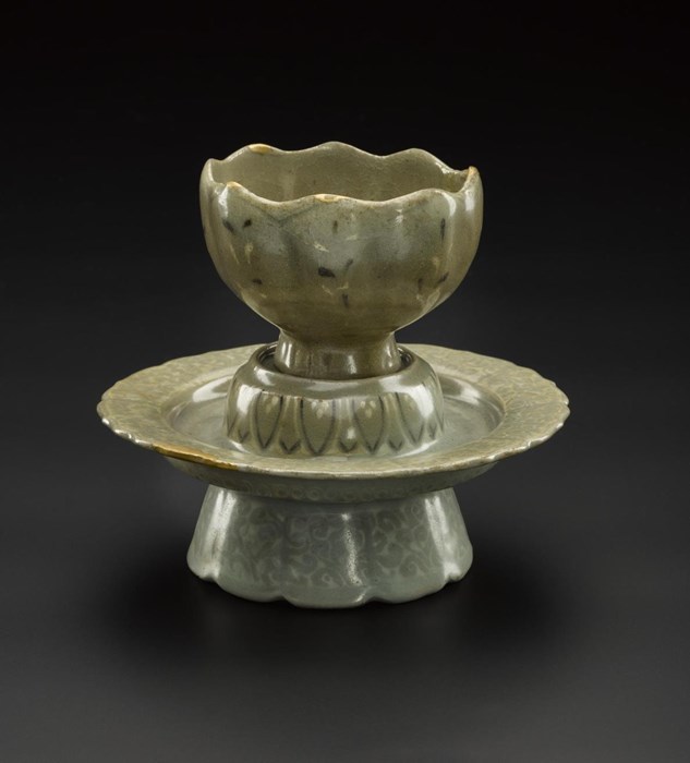 Fluted, chrysanthemum-shaped wine cup and stand of stoneware, decorated with inlaid designs (sanggam) of chrysanthemums and lotus petals in white and brown slip under a celadon glaze: Korea, Goryeo Dynasty, early 13th century.