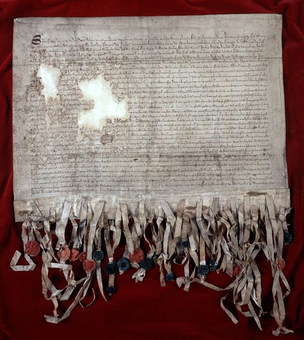 Heavily tattered document with dense Latin script and many tassels.