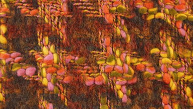 Close-up detail of wool and mohair woven tweed fabric in green, yellow, orange, and pink.