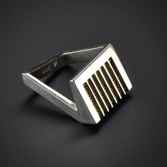 Right-handed silver ring with an angled top out of which lines have been pierced with gold wires set below, and with a square, angular shank: Scottish, by Dorothy Hogg, 1978