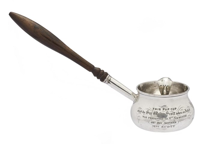 Silver feeding cup with a long wooden handle