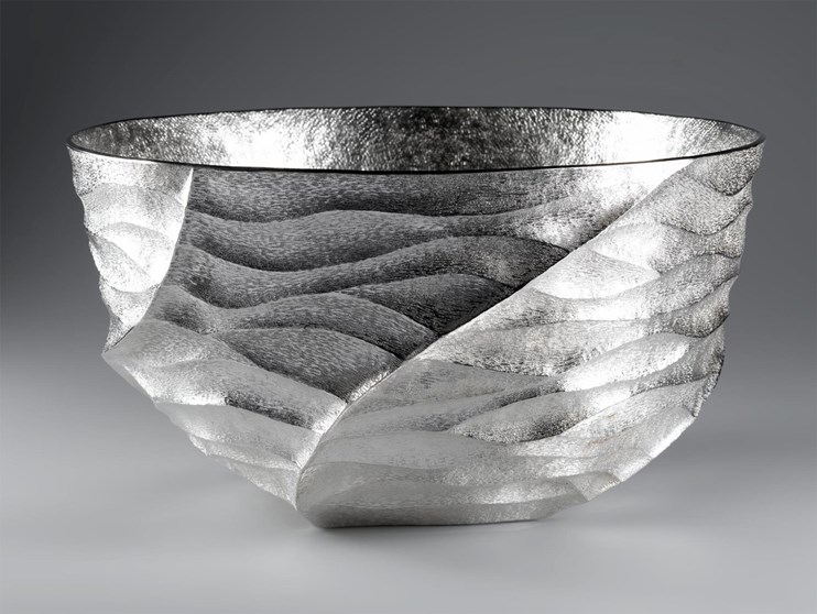 A siler bowl with wavy markings.