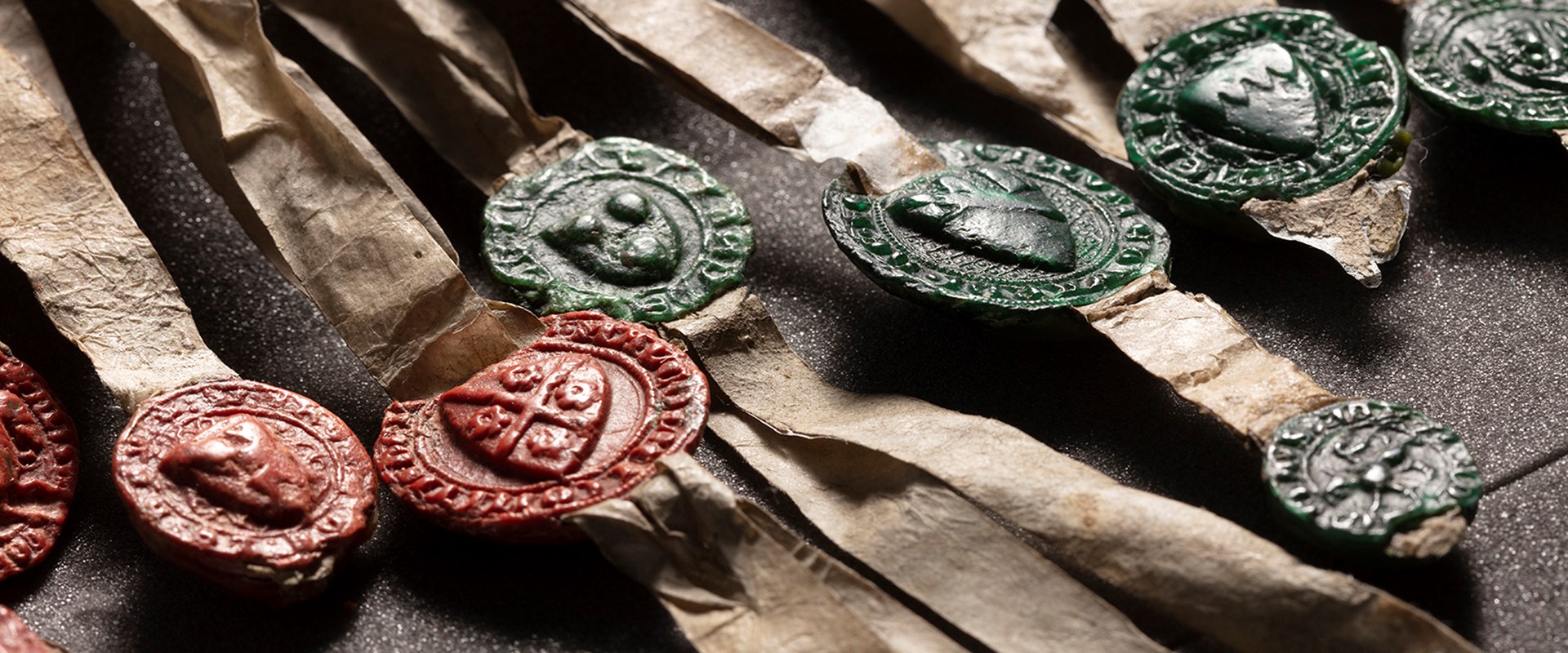 Red and green wax seals fixed to paper tassels attached to the Declaration of Arbroath.