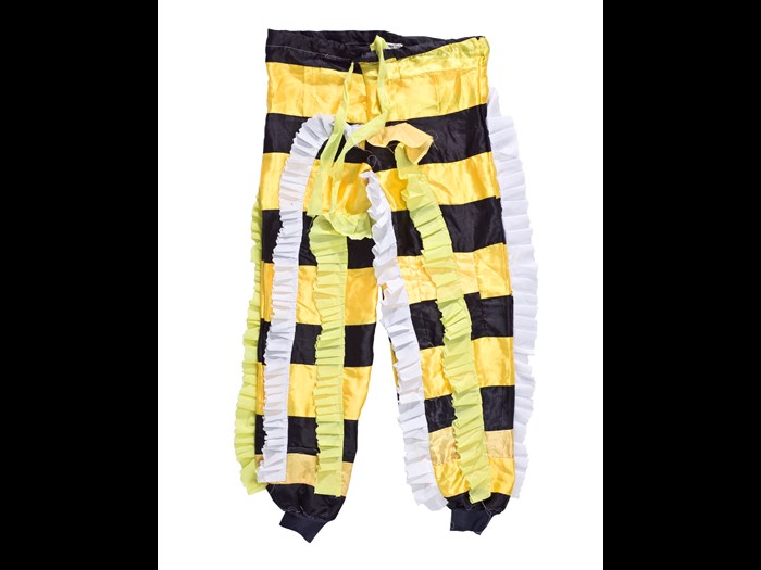 Drawstring trousers made to be worn as part of 'Fine Lady' fancy dress masquerade costume, made of yellow and black man-made fabric with yellow and white frills, originally purchased by Donatus Archibald Acquandoh (alias Hippies) from a tailor in Winneba: Africa, West Africa, Ghana, Winneba, 2000 