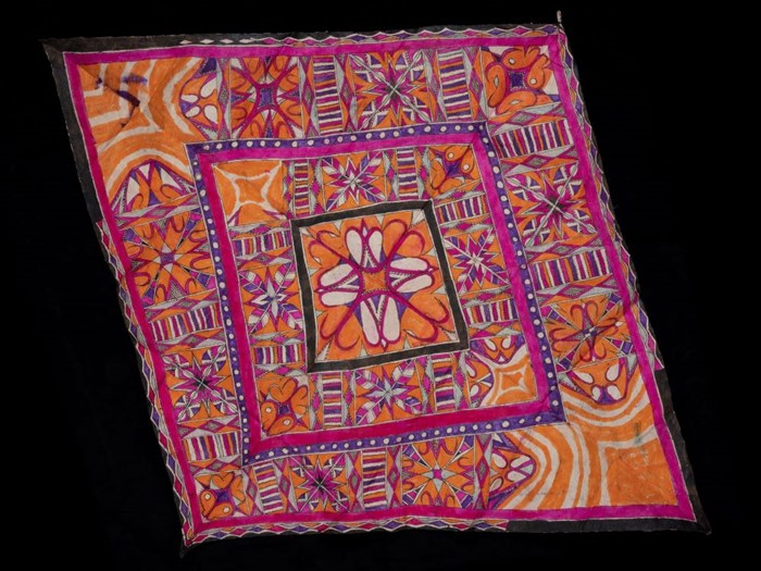 Square of barkcloth dense geometric patterns, brightly coloured in pink, purple, orange and red.