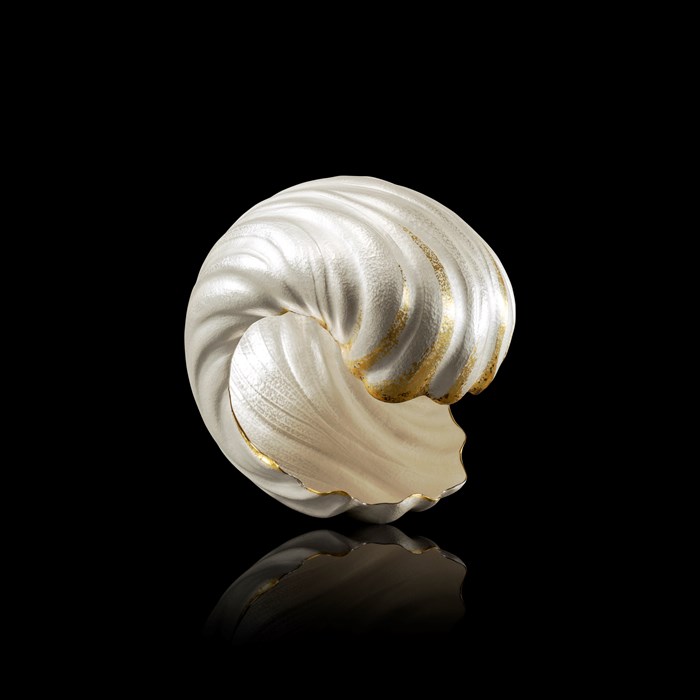 Silver sculpture in the shape of a cresting wave. Gold detailing highlights the curve of the wave, giving the sensation of movement
