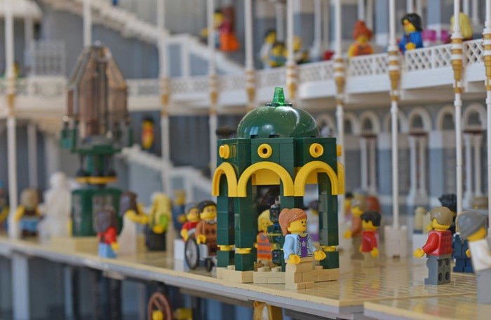 A lego model of the grand gallery of the National Museum of Scotland with several lego figures.