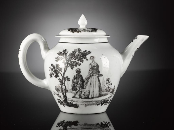Photo of a white teapot with a black illustration depicting a woman and a black child-servant.