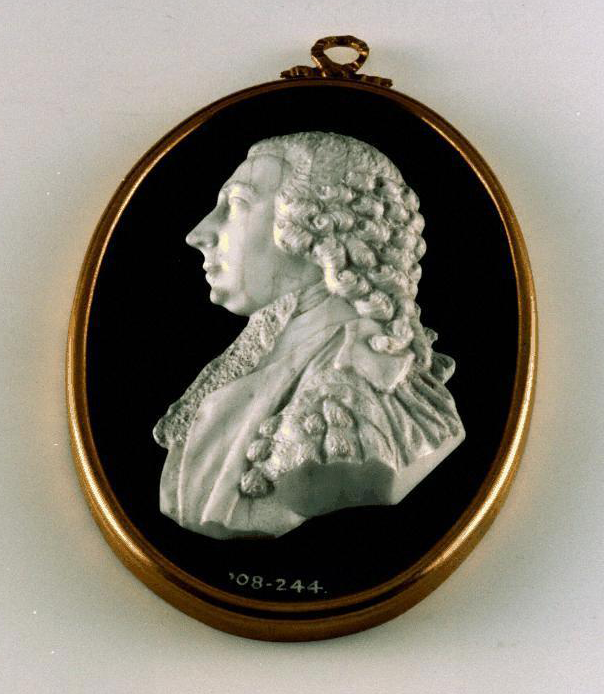 Medallion with a man's white cameo on it in profile.