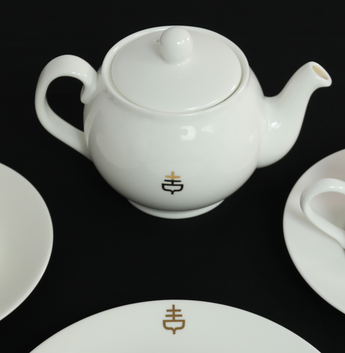 Close-up of the tea set showing the sailing ship logo.