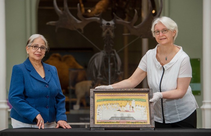 Naina Minhas and Friederike Voigt in the Grand Gallery of the National Museum of Scotland posing with a painting from the Archibald Swinton collection.