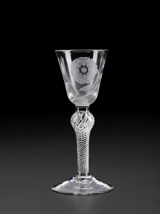 A stemmed wine glass with a carved floral design