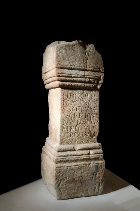 Stone altar shaped like a pillar with Latin inscriptions in the middle