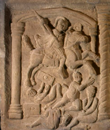 Relief sculpture showing a well-equipped mounted Roman riding over cherub-like naked native people, one holding a shield.