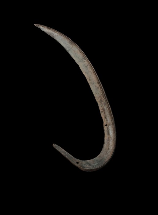Large scythe head resembling a fishing hook both in shape and position, set against a black background