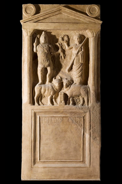 Dusty yellow altar with two humanoid figures and two cattle standing next to a small pillar