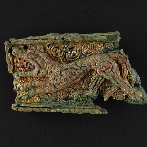 Rectangular gilt-bronze mount depicting a lion, reused as a brooch in the grave of a woman and infant from Westness, Rousay, Orkney, length 66mm, 
