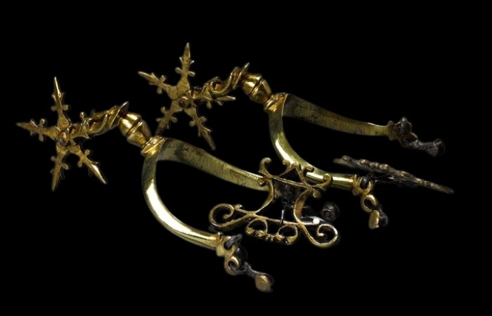 Pair of gilt brass rowel spurs. The spur is designed like a star or a sharp snowflake shape.