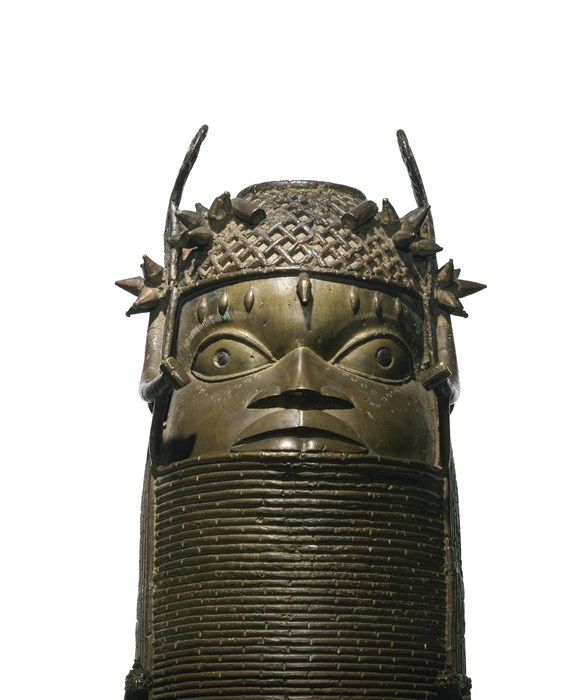 Very sturdy, strong-looking bronze head atop a coil-like design with large eyes, beads across the forehead and a thorny crown.