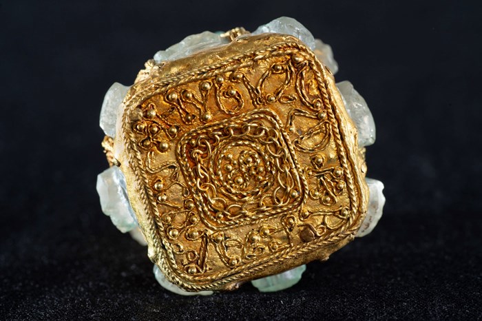 Square, golden base of the jar with golden, rope-like lines spelling the name 'Hyguald' around the edges.