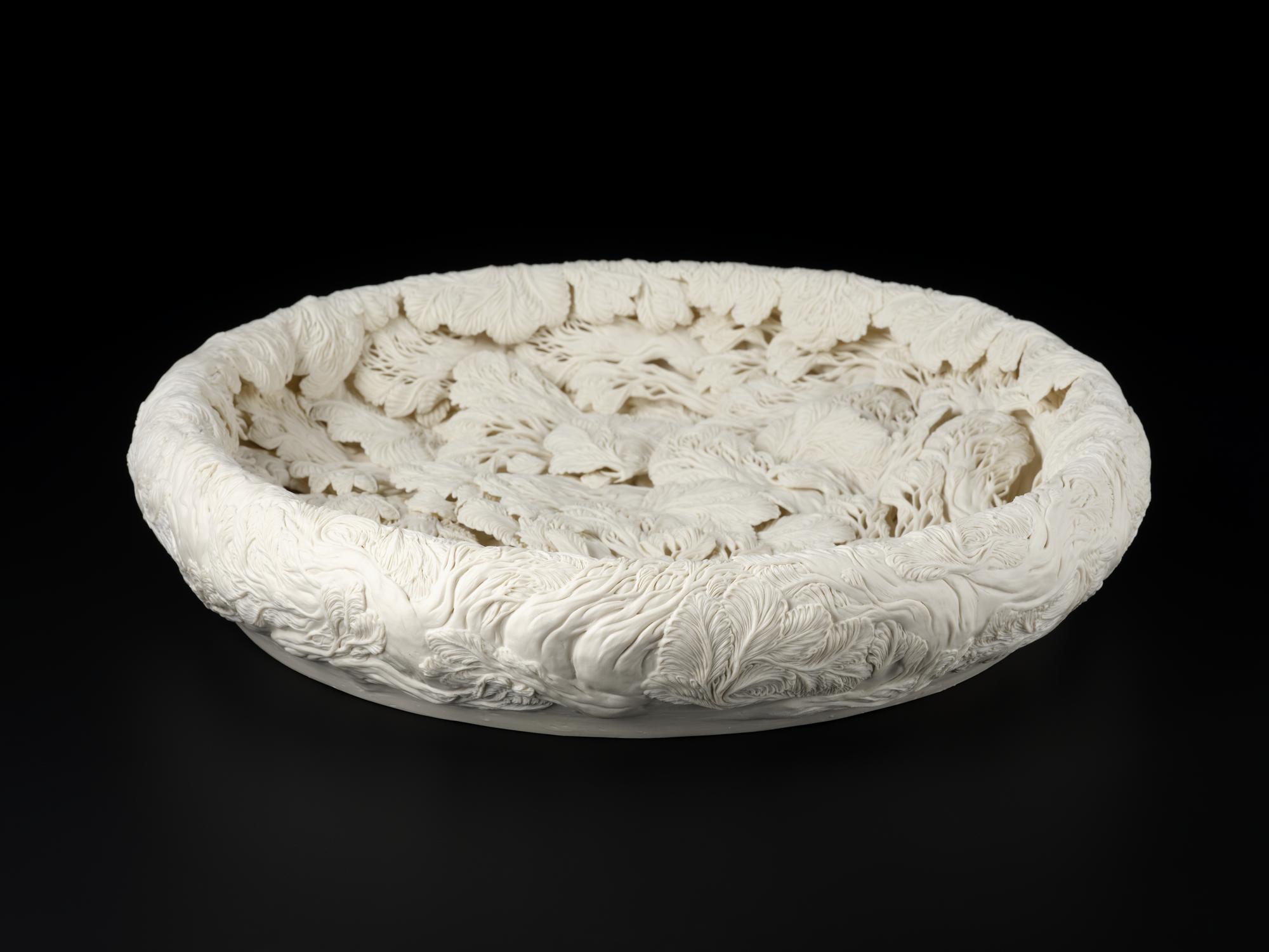 Japanese sculptural bowl of unglazed porcelain entitled 'A Large Pine Tree Pool' by Hitomi Hosono in 2010. It is decorated with sprig moulded pine tree branches flowing in water and enhanced with hand carving and piercing. V.2019.72,