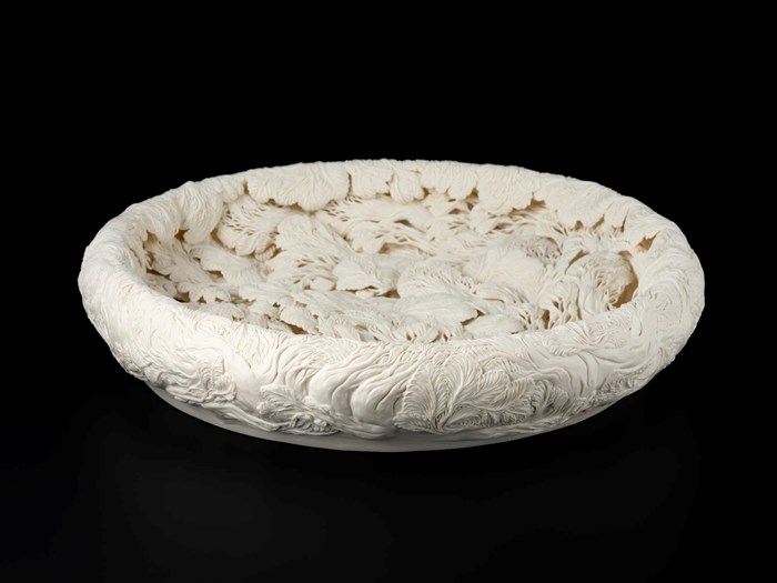 Japanese sculptural bowl of unglazed porcelain entitled 'A Large Pine Tree Pool' by Hitomi Hosono in 2010. It is decorated with sprig moulded pine tree branches flowing in water and enhanced with hand carving and piercing. V.2019.72,