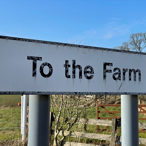 Direction sign that reads "To the farm". 