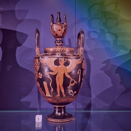 Urn depicting a naked human figure with wings. Image has a transparent rainbow overlay.