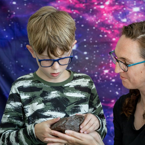 A child and adult looking at a geological specimen.