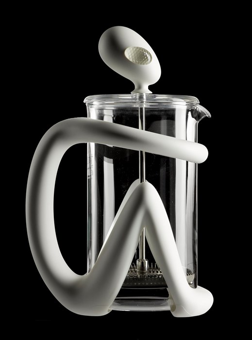 Sculpture of a smooth, white stick-figure 'alien', crouched with bent knees and arms wrapped around a glass coffee press. The alien's expressionless head is the handle for the plunger.