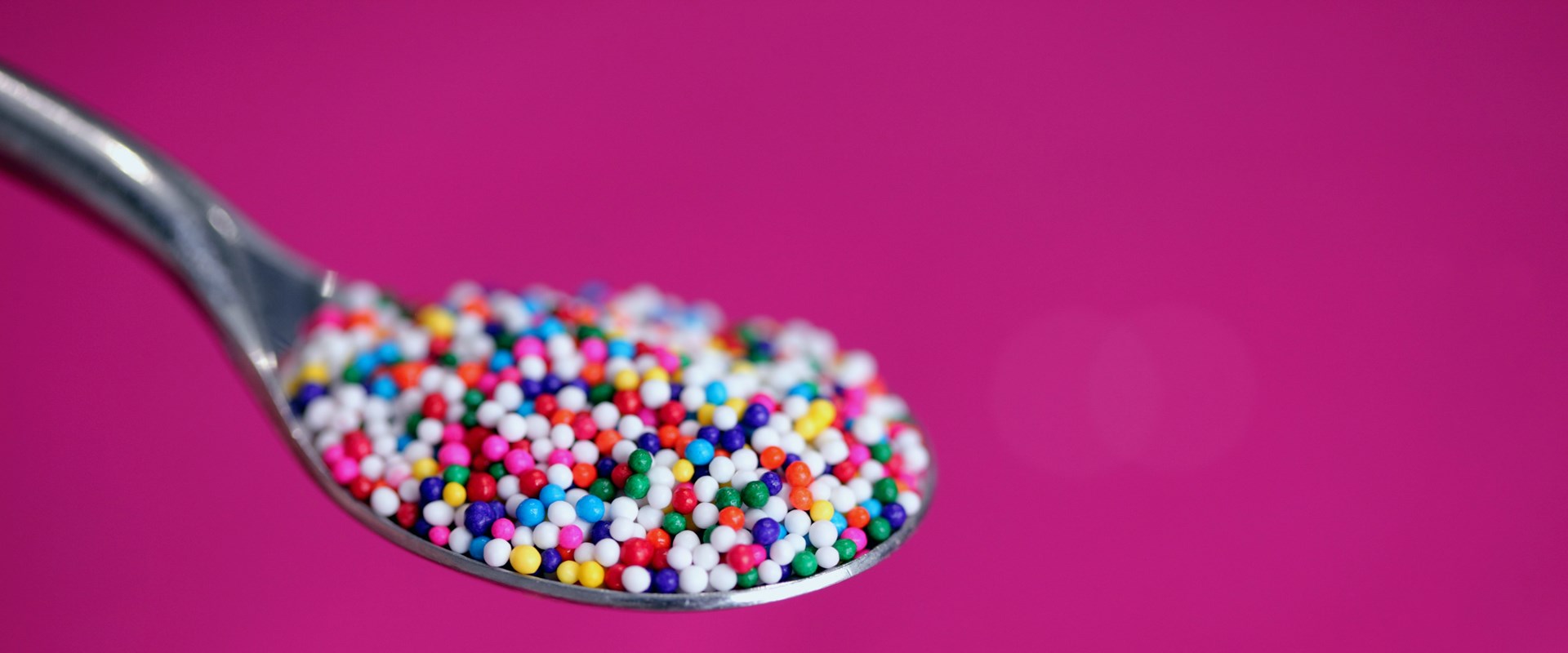 A spoonful of coloured sugar. Photo by Alexander Grey on Unsplash