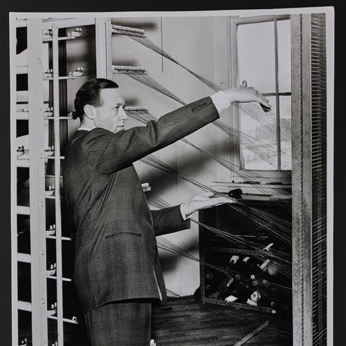 Black and white photo of Bernat Klein checking a mill.