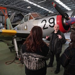 Two visitors viewing the aircraft in the Conservation Hangar with a member of staff.