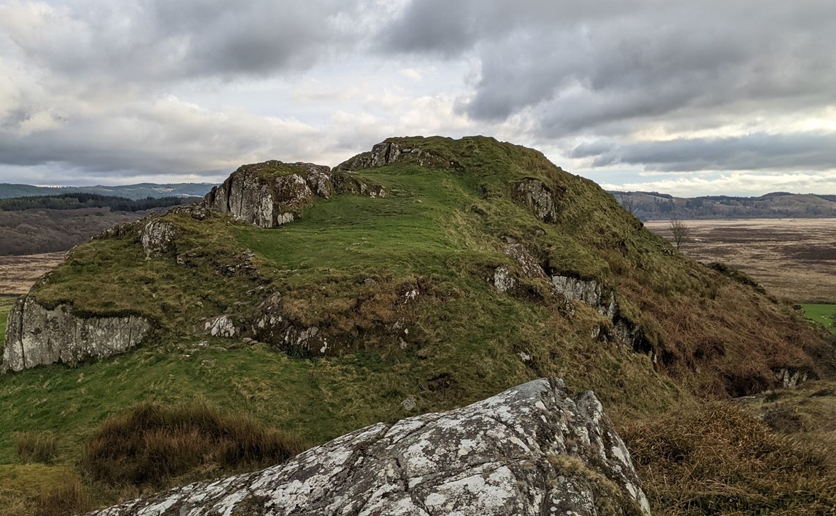 A rocky crag and a view to the old Citiadel at Dunadd hillfort.